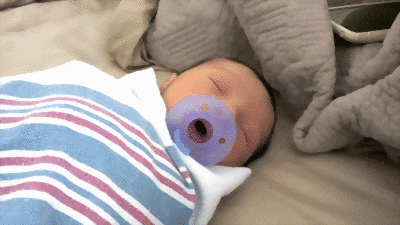 Bebé con chupón morado