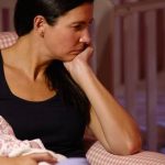 Mamá triste con bebé en brazos