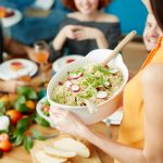 Mujer sirviendo una comida donde los alimentos son saludables