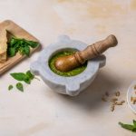 Mortero con pesto y sus ingredientes