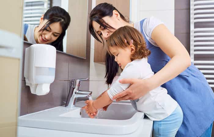 mamá ayudando a su hijo a lavarse las manos