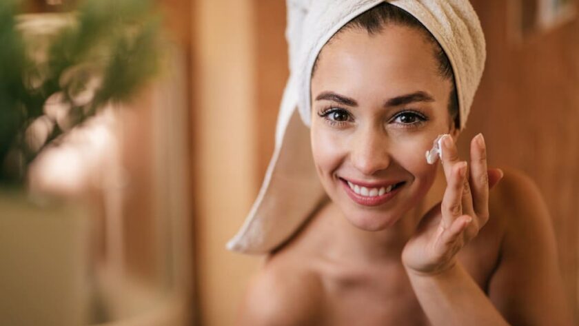 Mujer con piel radiante aplicando crema